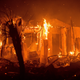Flames consume a structure as the Lilac fire burns in Bonsai, California earlier today. (Image: AP)